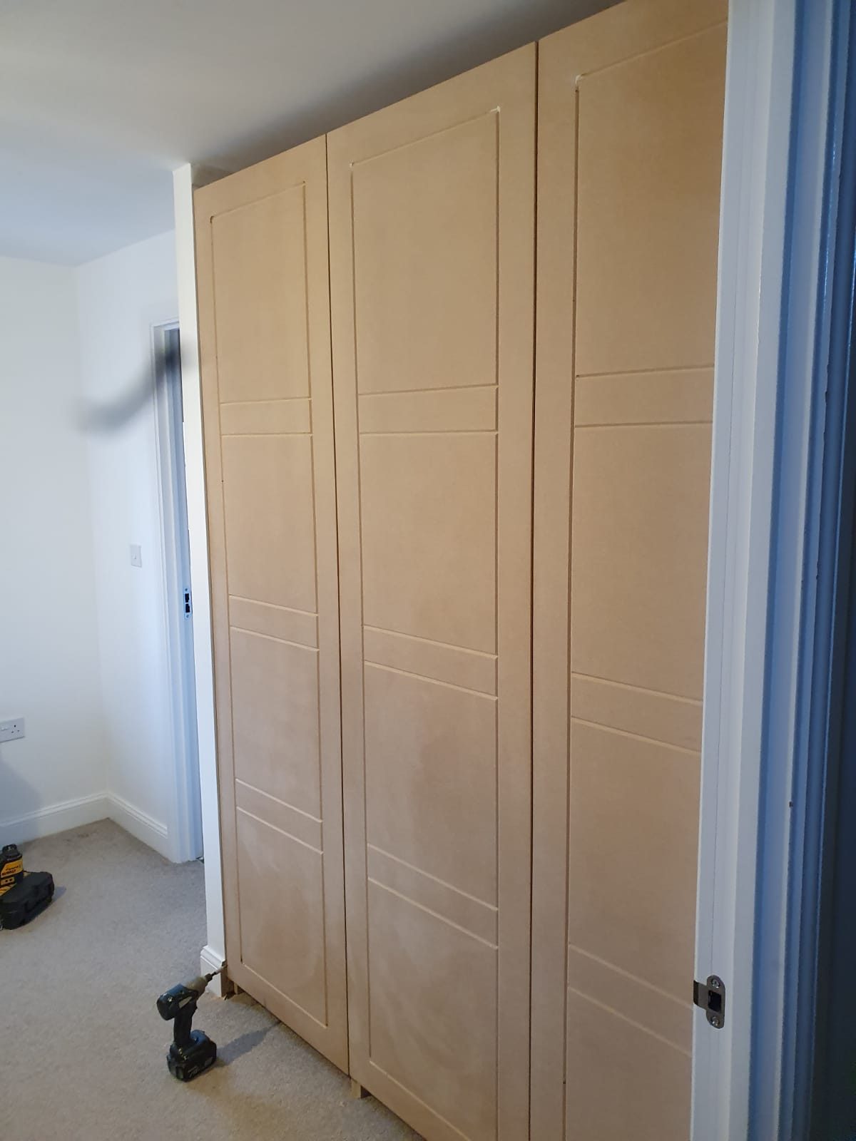 Oak fitted wardrobes built floor to ceiling in a bedroom