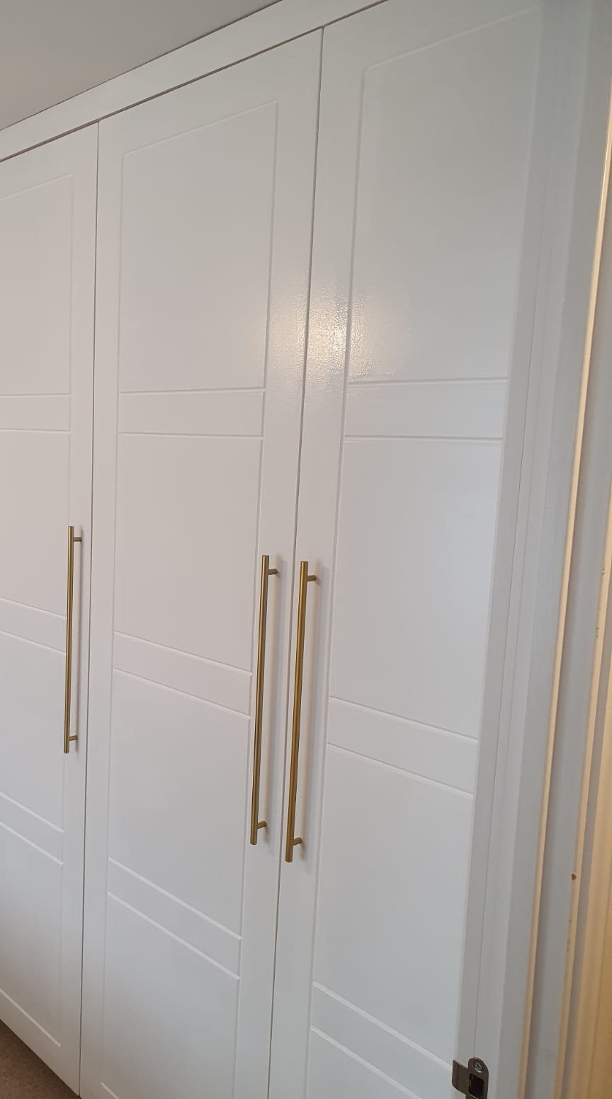 Fitted wardrobes with tall brass handles, scribed to the ceiling line, Thomas Joinery Services, Bedford
